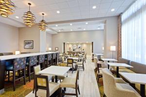 a restaurant with tables and chairs and a bar at Hampton Inn Sault Ste Marie, MI in Sault Ste. Marie