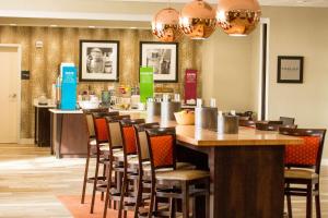 un restaurante con un bar largo con sillas en Hampton Inn McPherson en McPherson