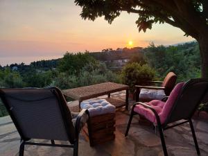 a patio with a table and chairs and the sunset at Panorama Studio Afetes in Afétai
