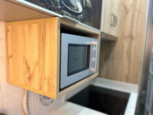 eine Mikrowelle in einem Holzschrank in einer Küche in der Unterkunft Casa Daniella Vivienda B in Ingenio