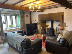 a living room with a couch and a fireplace at 17th Century Cottage with Hidden Garden in Steeton