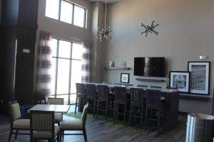 a dining room with tables and chairs and a television at Hampton Inn & Suites Guthrie, OK in Guthrie