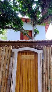 uma porta de madeira com um sinal em cima em Afeto Caraíva em Caraíva