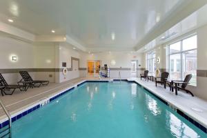 a swimming pool with blue water in a building at Hilton Garden Inn Martinsburg in Martinsburg