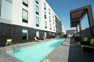 a swimming pool in front of a building at Home2 Suites by Hilton Tulsa Hills in Tulsa