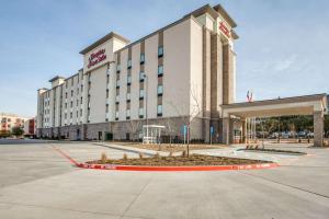 un edificio de hotel con un aparcamiento enfrente en Hampton Inn & Suites Dallas-Central Expy/North Park Area en Dallas