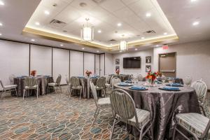 a conference room with tables and chairs and a screen at Hampton Inn & Suites Dallas-Central Expy/North Park Area in Dallas