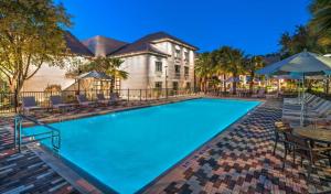 una gran piscina con mesas y sombrillas en DoubleTree by Hilton Gainesville, en Gainesville