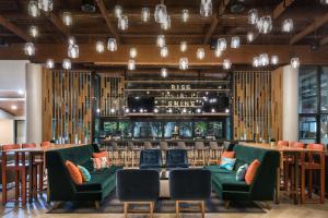 un restaurante con sillas verdes y un bar en DoubleTree by Hilton Gainesville en Gainesville