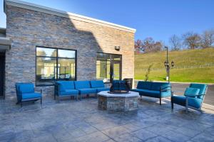 eine Terrasse mit blauen Stühlen und einer Feuerstelle in der Unterkunft Hampton Inn & Suites Albany-East Greenbush, NY in East Greenbush