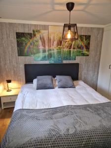 een slaapkamer met een groot bed en een schilderij aan de muur bij Chalet in Putten in Putten