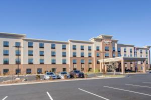 un gran edificio con coches estacionados en un estacionamiento en Hampton Inn Boston - Westborough en Westborough