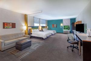冈萨雷斯Home2 Suites By Hilton Gonzales的配有床和书桌的酒店房间