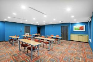 冈萨雷斯Home2 Suites By Hilton Gonzales的一个带桌椅的教室和蓝色的墙壁 更多23张照片