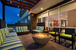een patio met 2 stoelen en een vuurplaats bij Home2 Suites By Hilton Baton Rouge in Baton Rouge