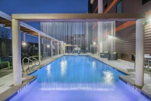 Home2 Suites By Hilton Austin Airport في أوستن: مسبح كبير في مبنى في الليل