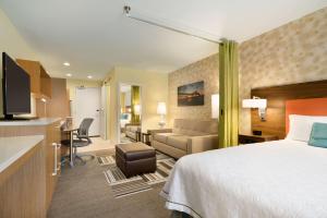 um quarto de hotel com uma cama e uma sala de estar em Home2 Suites By Hilton Baton Rouge em Baton Rouge