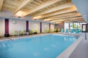 a large swimming pool with chairs and tables at Home2 Suites By Hilton Chicago Schaumburg in Schaumburg