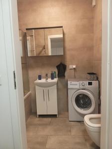 a bathroom with a washing machine and a sink at Apartament Cztery Pory Roku Gdańsk in Gdańsk