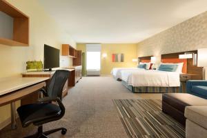 a hotel room with two beds and a desk at Home2 Suites By Hilton Middleburg Heights Cleveland in Middleburg Heights