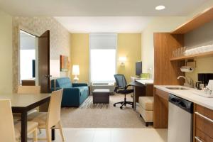 eine Küche und ein Wohnzimmer mit einem blauen Sofa in der Unterkunft Home2 Suites By Hilton Middleburg Heights Cleveland in Middleburg Heights