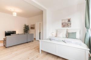 a white bedroom with a large bed and a television at Stilvolles Apartment für 4 Pers. in Bremen