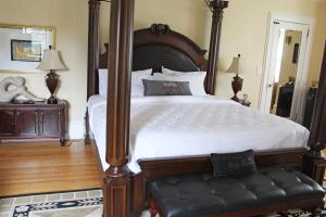 Grey Gables Inn في بيمبروك: غرفة نوم بسرير كبير مع اطار خشبي