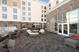 a patio with chairs and tables and a building at Homewood Suites by Hilton Concord in Concord