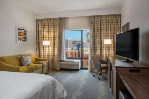 ein Hotelzimmer mit einem Bett und einem Flachbild-TV in der Unterkunft Hampton Inn & Suites Newport/Cincinnati, KY in Newport