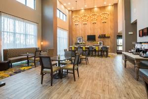 ein Restaurant mit Tischen und Stühlen und ein Esszimmer in der Unterkunft Hampton Inn & Suites Colleyville DFW Airport West in Colleyville