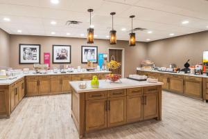 Hampton Inn & Suites Colleyville DFW Airport West في Colleyville: مطبخ كبير مع خزائن خشبية وعدادات