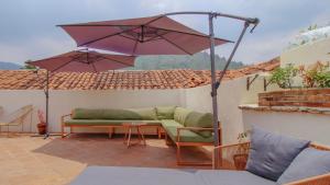 安地瓜的住宿－Flore Hostel，一个带沙发和遮阳伞的庭院