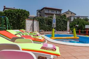 a row of empty chairs next to a swimming pool at Apartment Pool&Garden in Rijeka