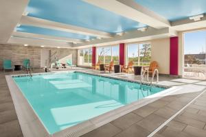 una gran piscina con agua azul en una habitación de hotel en Home2 Suites by Hilton Woodbridge Potomac Mills, en Woodbridge