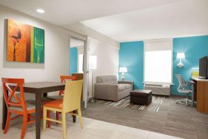 a living room with a table and chairs and a couch at Home2 Suites by Hilton Woodbridge Potomac Mills in Woodbridge