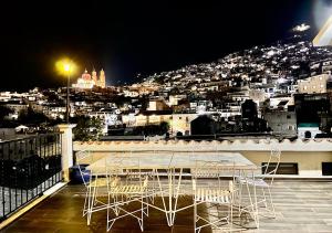 a table and chairs on a balcony at night at Casa céntrica con garaje in Taxco de Alarcón
