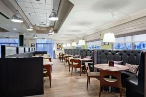 un comedor con mesas, sillas y ventanas en Doubletree By Hilton Glasgow Strathclyde, en Bellshill