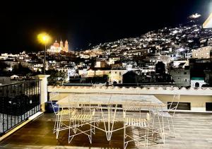 una mesa y sillas en un balcón por la noche en Casa céntrica con garaje, en Taxco de Alarcón