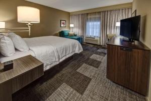 ein Hotelzimmer mit einem Bett und einem Flachbild-TV in der Unterkunft Hampton Inn & Suites By Hilton Nashville Hendersonville Tn in Hendersonville