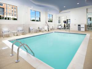 uma piscina num quarto de hotel com cadeiras e mesas em Hampton Inn Wilmington Downtown em Wilmington