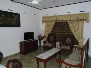 sala de estar con sillas, TV y sofá en Shalona Holiday Home en Galle