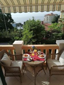 - une table avec des assiettes de nourriture sur une terrasse dans l'établissement Villa Salus, Apartment Maruna, à Opatija