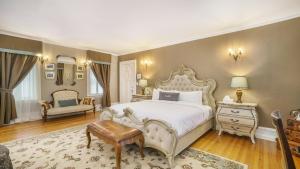 a bedroom with a large white bed and a chair at Grey Gables Inn in Pembroke