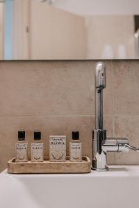 a group of four bottles of soap sitting next to a sink at La Mer in Agios Rokkos