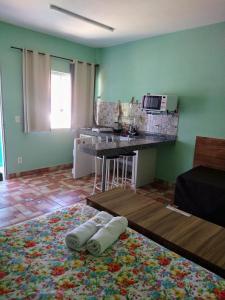 Zimmer mit einer Küche mit einer Theke und einem Tisch in der Unterkunft Águas de Carrancas FLATS in Carrancas