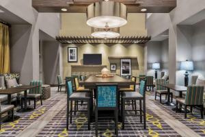 a dining room with tables and chairs and a chandelier at Hampton Inn & Suites Los Angeles/Hollywood, CA in Los Angeles