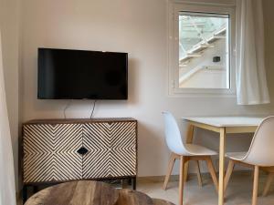 ein Wohnzimmer mit einem Tisch und einem TV an der Wand in der Unterkunft Lagunas Home, bajo con terraza al lado de la playa in Vera