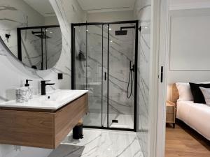 een badkamer met een glazen douche en een wastafel bij Cindy Rooms in Termoli