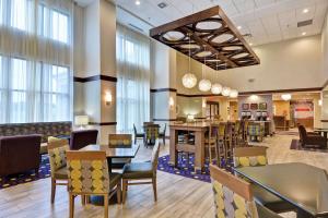 a restaurant with tables and chairs and windows at Hampton Inn Suites Ashland, Ohio in Ashland