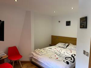 a bedroom with a bed and a red chair at Casa Andreea in Vatra Dornei